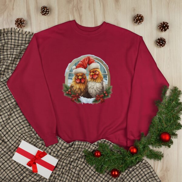 Sweatshirt - A festive illustration featuring two chickens adorned with fluffy Santa hats, set against an arched window pane overlooking a snowy scene.