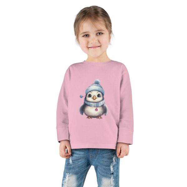 Tee - A cute baby owl, donning a pale blue winter hat with a fluffy pom-pom and matching scarf, gazes with large, inquisitive eyes, surrounded by a dreamy background with twinkling stars.