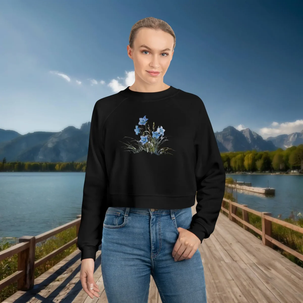 Woman wearing a black cropped sweatshirt with a delicate blue floral illustration
