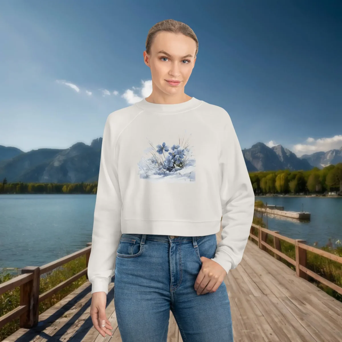 Woman wearing a white cropped sweatshirt with a soft blue floral watercolor-style illustration