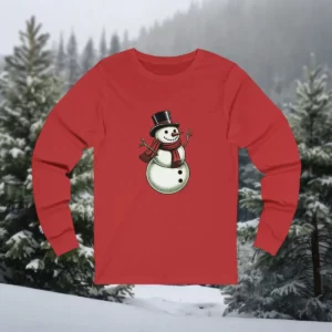 Long-sleeve shirt featuring a Victorian-style snowman with a top hat, red scarf, and twig arms, set against a snowy forest background.