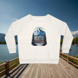 Flatlay of white sweatshirt with a printed design of a city skyline, mountains, and forest silhouettes