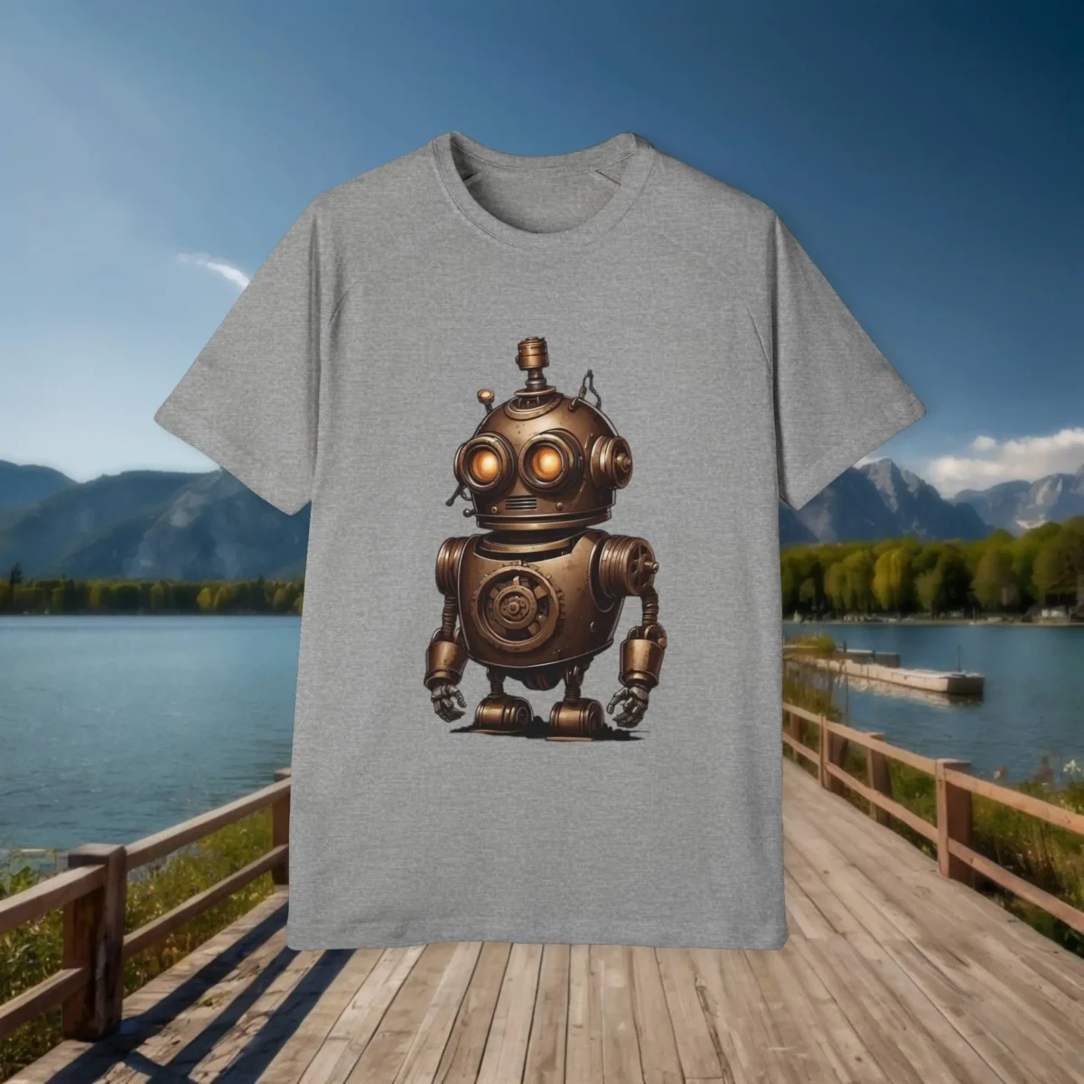 Flat lay of grey t-shirt with a steampunk robot in bronze tones and orange glowing eyes, displayed against a scenic lake and mountain background.