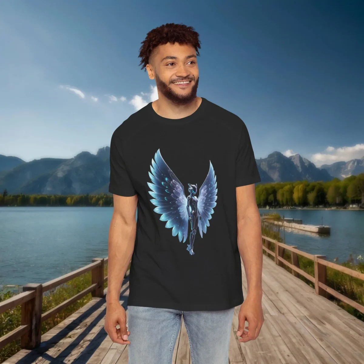 Man wearing a black raglan t-shirt with a glowing digital illustration of a futuristic woman with large angelic wings, standing by a lake and mountains.