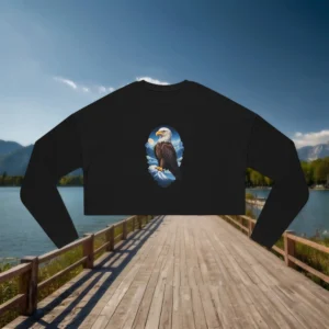 Flat lay of a black cropped sweatshirt with a bald eagle on a snowy mountain graphic