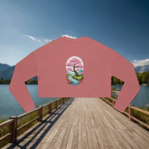 Flat lay of a pink cropped sweatshirt with a cherry blossom and mountain landscape graphic