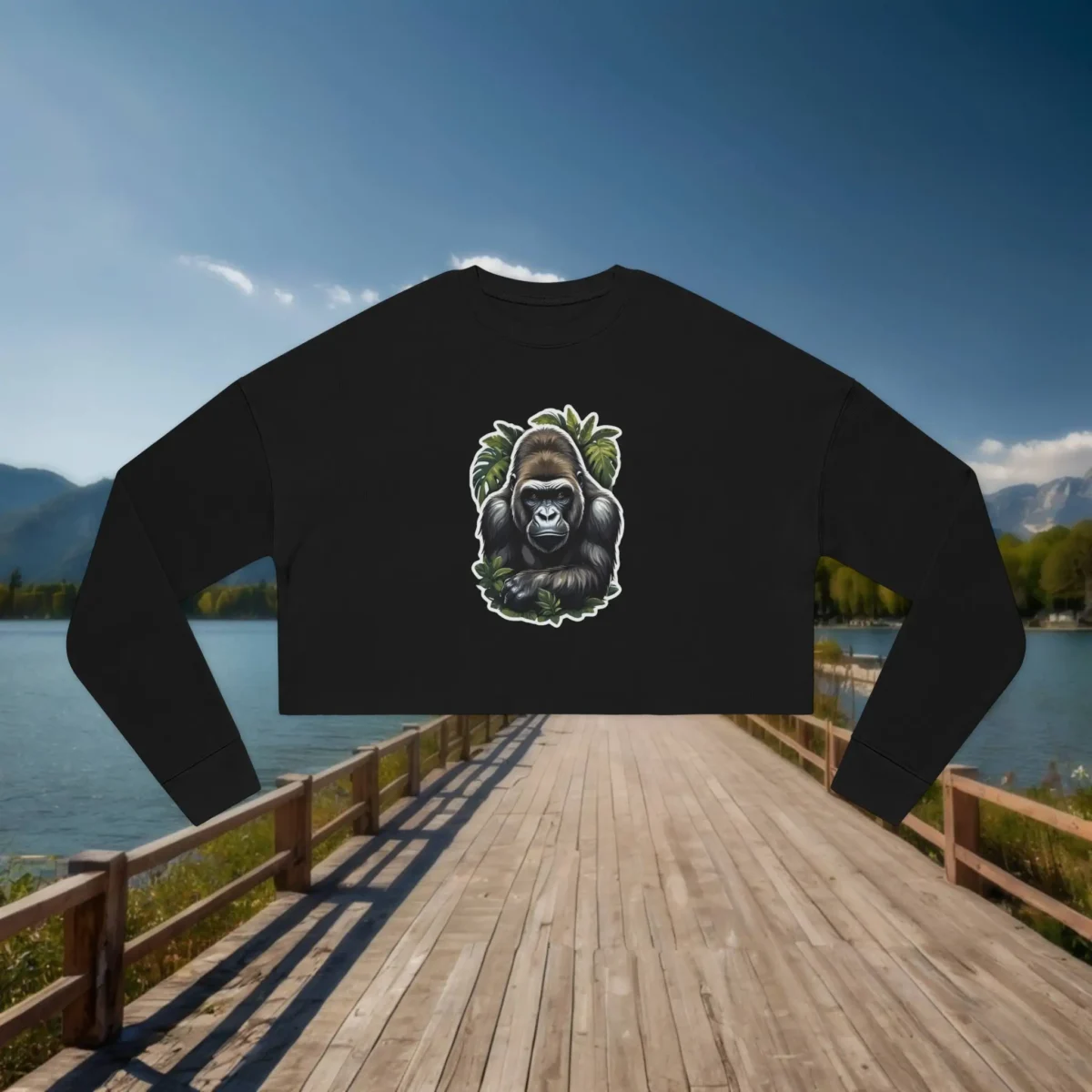 Flat lay of black cropped sweatshirt with illustrated gorilla and green jungle background
