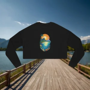 Flat lay of a black cropped sweatshirt with a vibrant tropical island sunset design