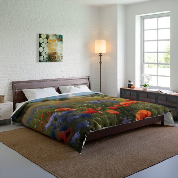 A bedroom with a Comforter depicting poppies and wildflowers, placed on a bed in a bright room with a large window, wooden furniture, and a soft rug.