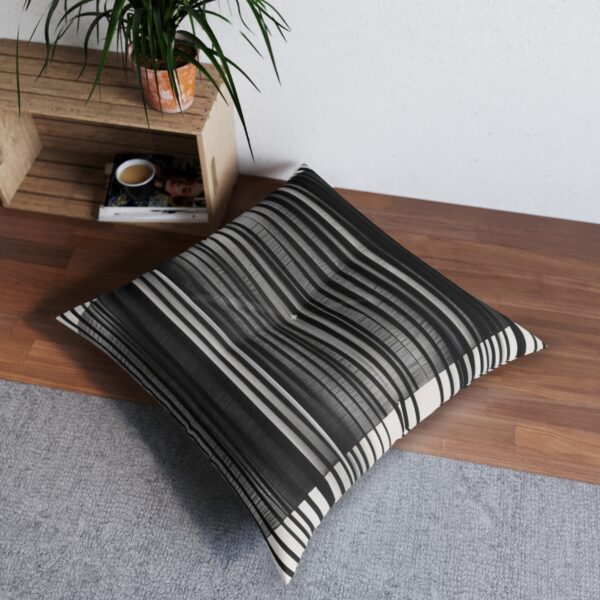 Tufted floor pillow with black and white vertical lines and grid pattern