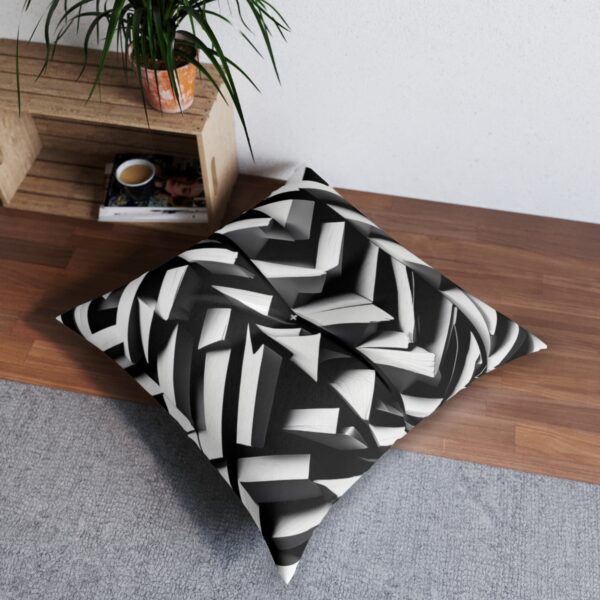 Bold tufted floor pillow with monochrome parallelogram pattern creating a woven effect