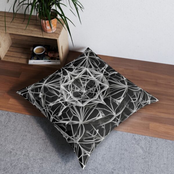 Tufted floor pillow with delicate geometric lines forming a web in black and white