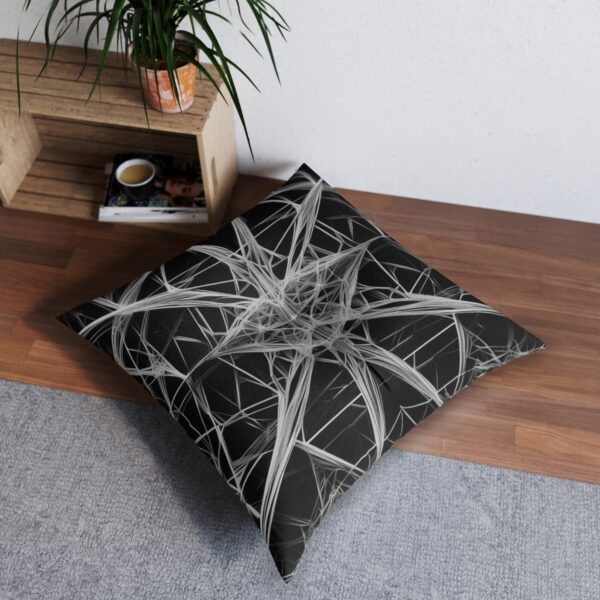 Tufted floor pillow with a web of thin precise geometric lines in black and white