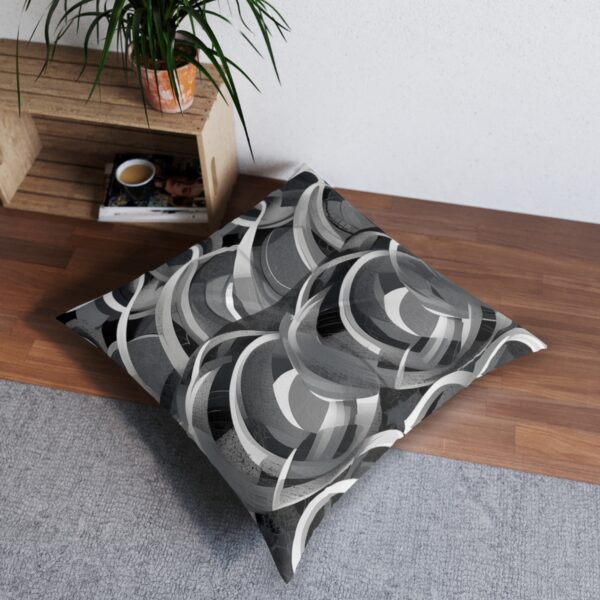 Swirling grayscale tufted floor pillow with overlapping circles design