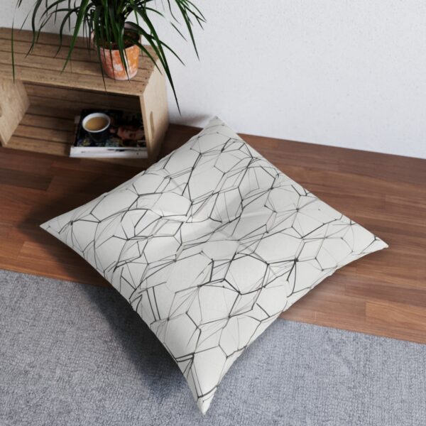 Tufted floor pillow with intricate pattern of intersecting lines and polygons on white