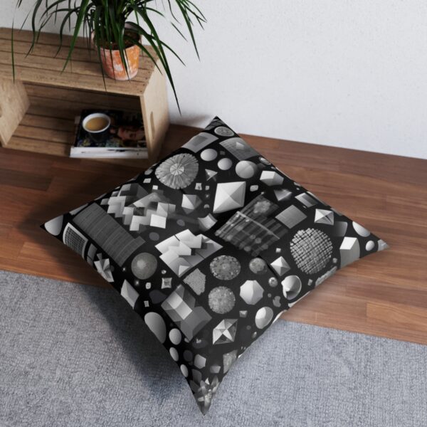 Tufted floor pillow with dynamic assortment of geometric shapes in grayscale