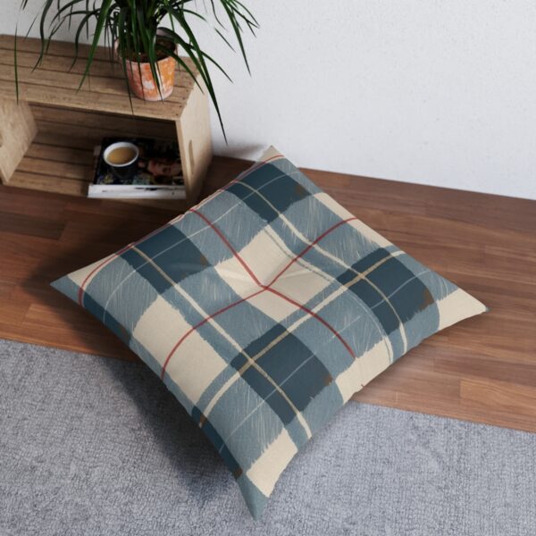 Muted plaid tufted floor pillow in subdued greens and beiges with red accents