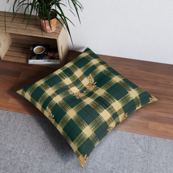 Hunter green plaid tufted floor pillow with golden trim on wooden floor