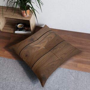 Square tufted floor pillow with rich wood grain texture on a living room floor.