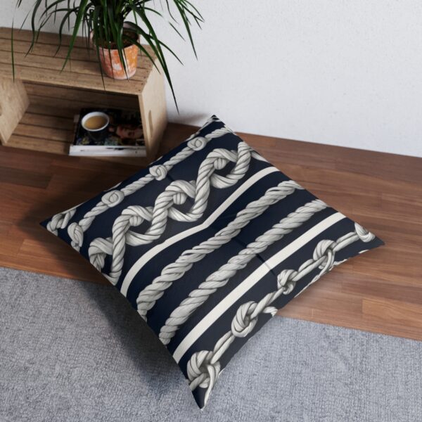 Tufted floor pillow with classic knotted ropes across navy stripes