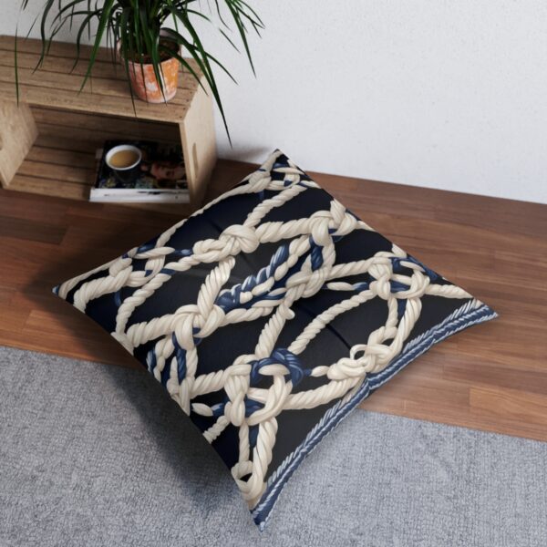 Tufted floor pillow adorned with an array of knotted ropes against navy stripes