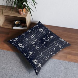 Whimsical anchors float amongst stars over dark blue waves floor pillow