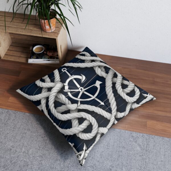 Navy tufted floor pillow with helms wheel and encircled by twisted ropes