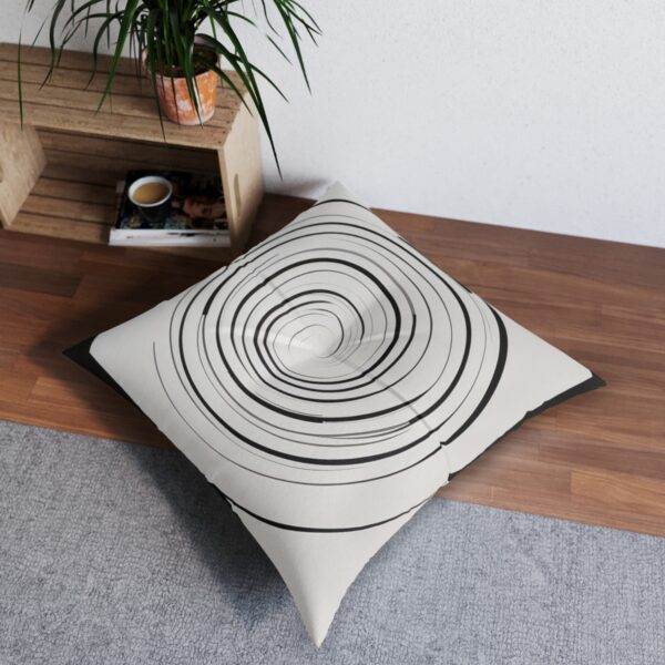 Chic white tufted floor pillow with sleek black spiral design