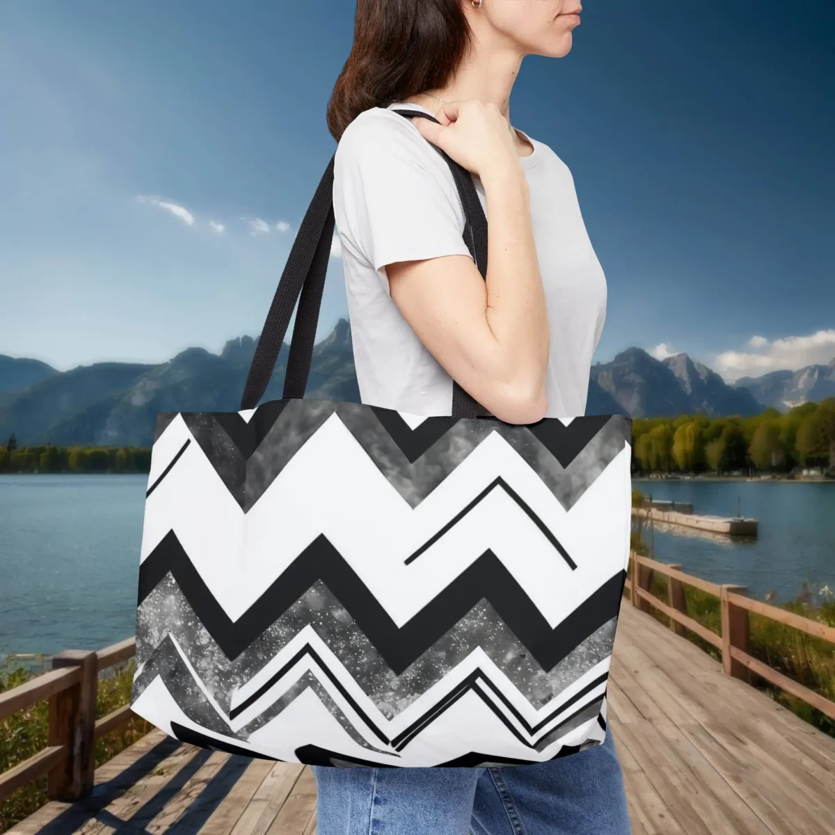 Woman carrying a weekender tote bag with a black and white chevron stripe design