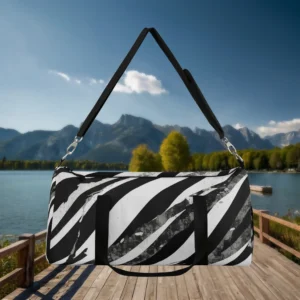 Large abstract black and white striped duffel bag with black handles, suspended above a lakeside wooden dock.