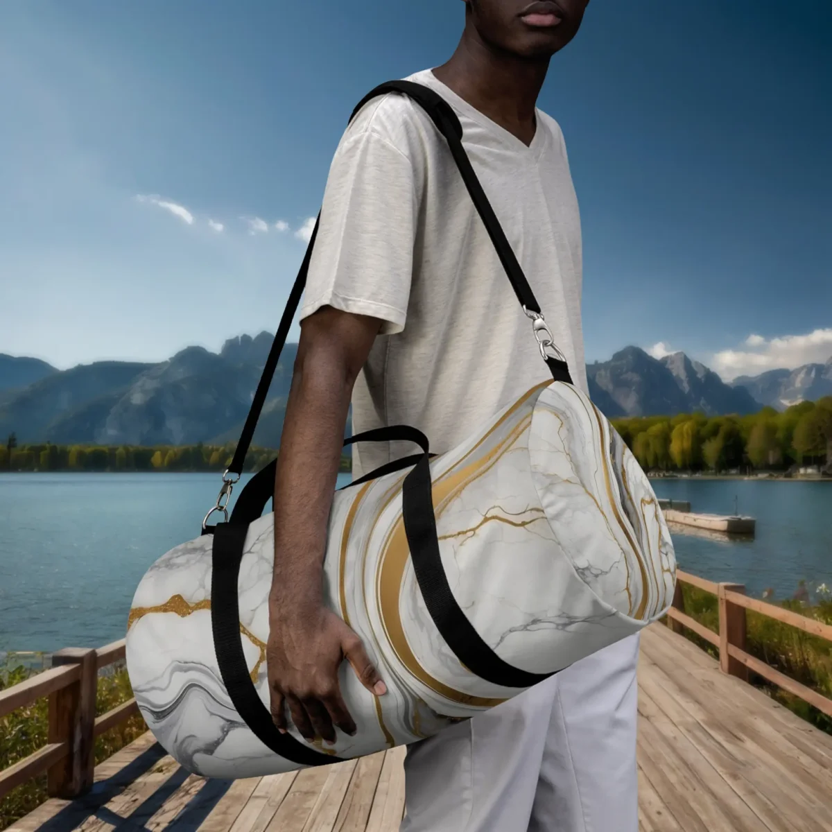 Man holding a large duffel bag with marble print and gold accents by the lake.
