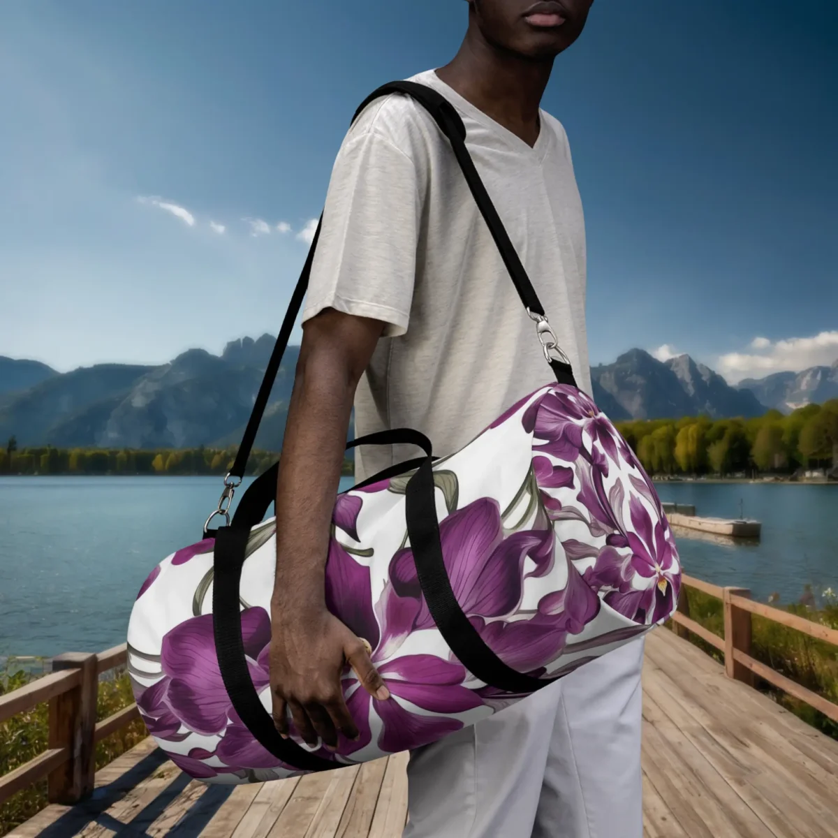 Man carrying a large duffel bag with purple orchid print on shoulder at lakeside dock.