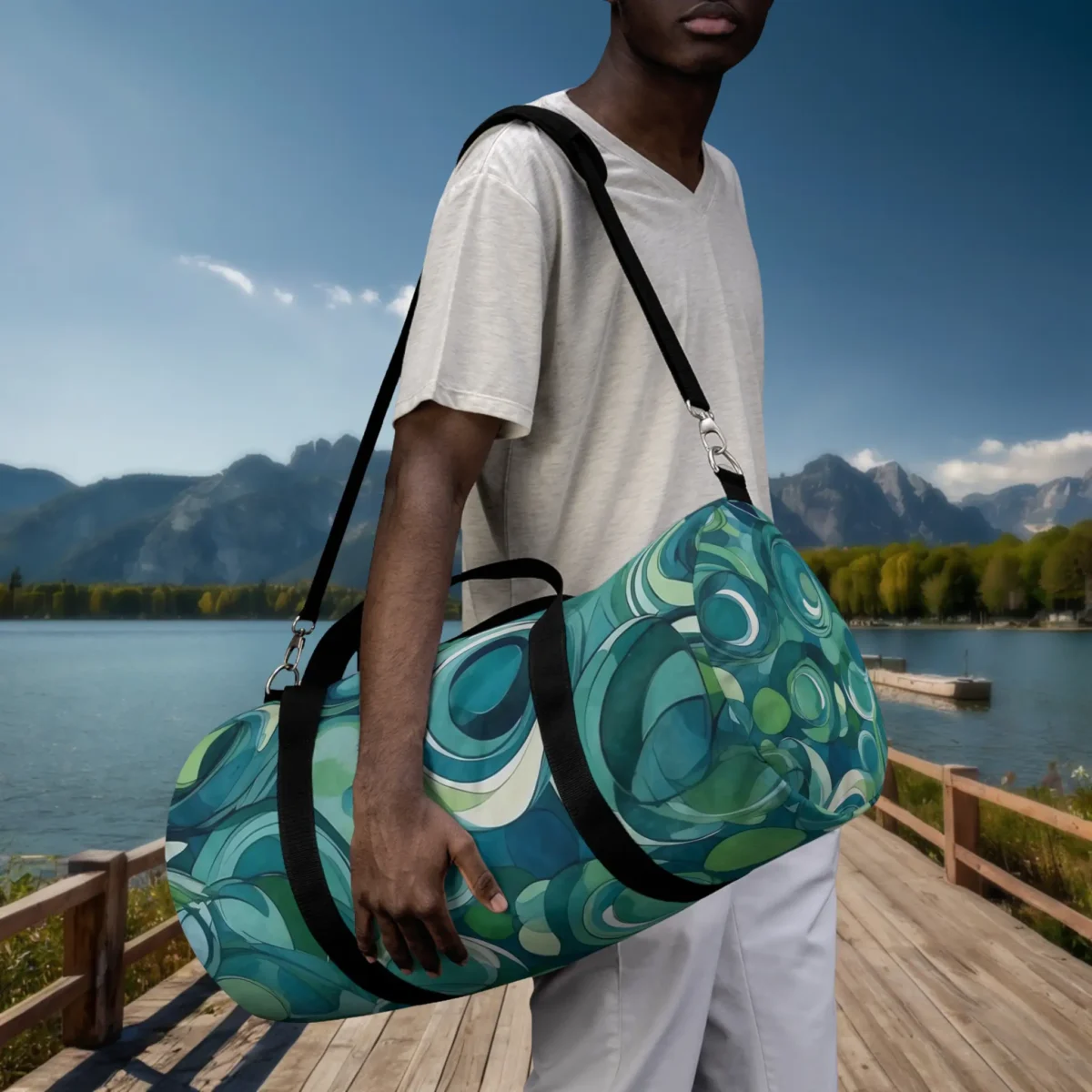 Man carrying a large duffel bag with layered circle pattern in blue and green tones.