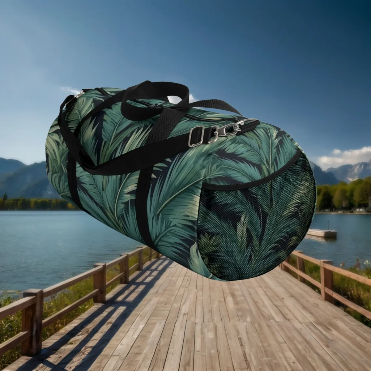 Side mesh pocket view of large duffel bag with green palm leaf design and black straps.