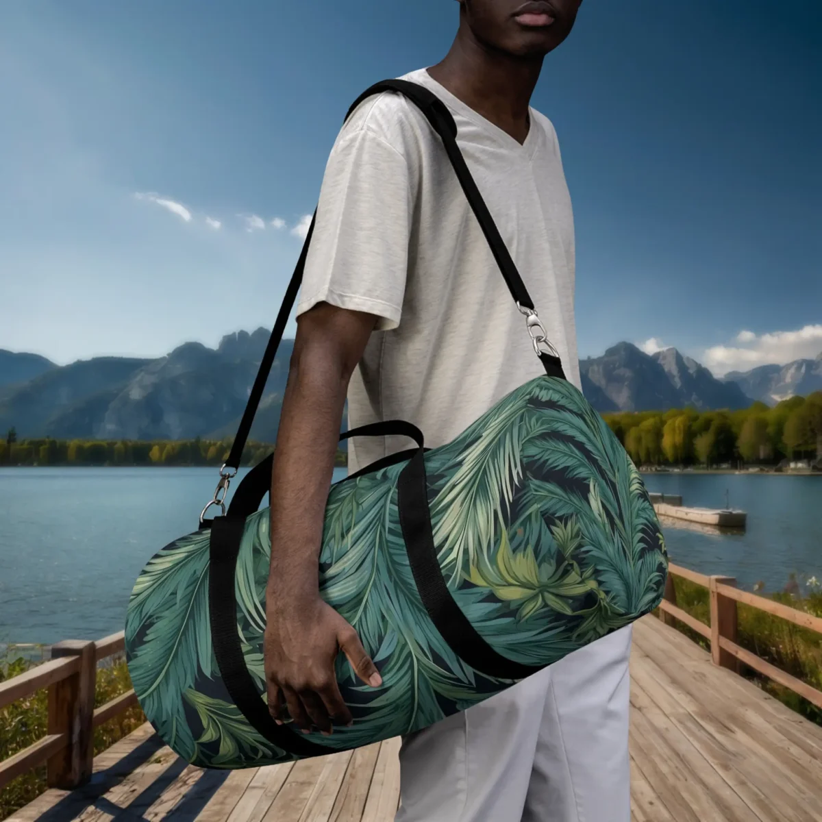 Man holding a large duffel bag with tropical palm frond design in green tones.