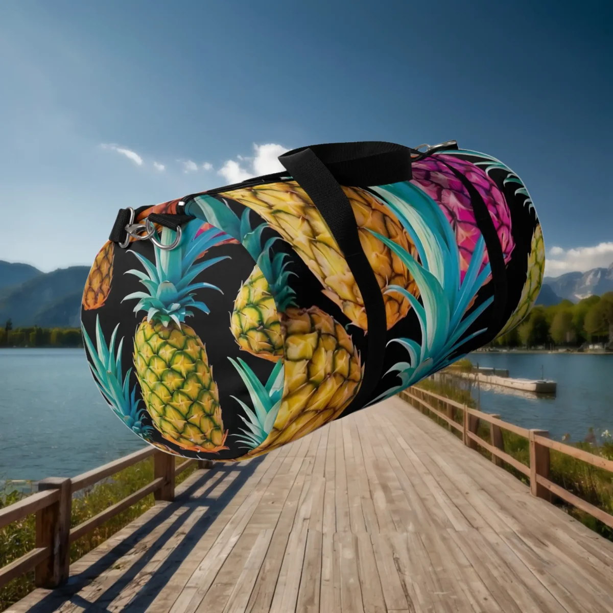Angled view of a large duffel bag with vivid pineapple illustrations on a dark base.