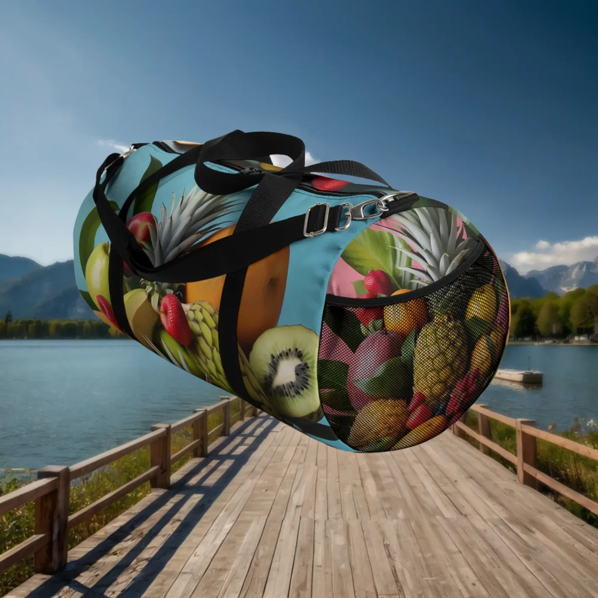 Side mesh pocket view of large duffel bag with tropical fruits on blue and pink background.