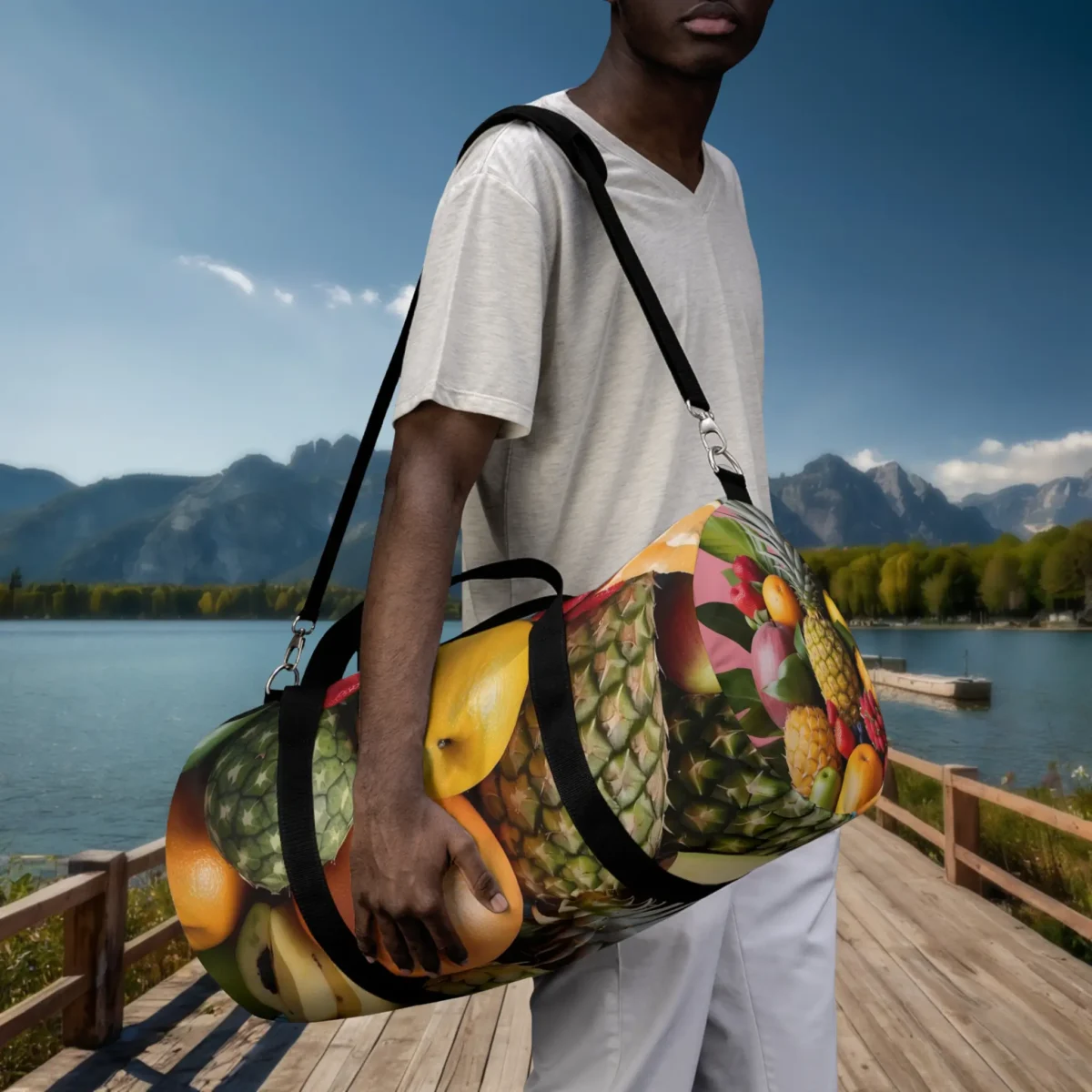 Man holding a large duffel bag with vivid tropical fruit collage print.