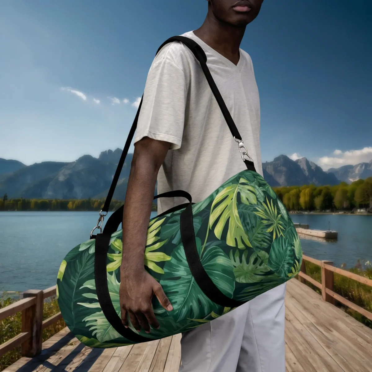 Man carrying a large duffel bag with green tropical leaf pattern on shoulder.