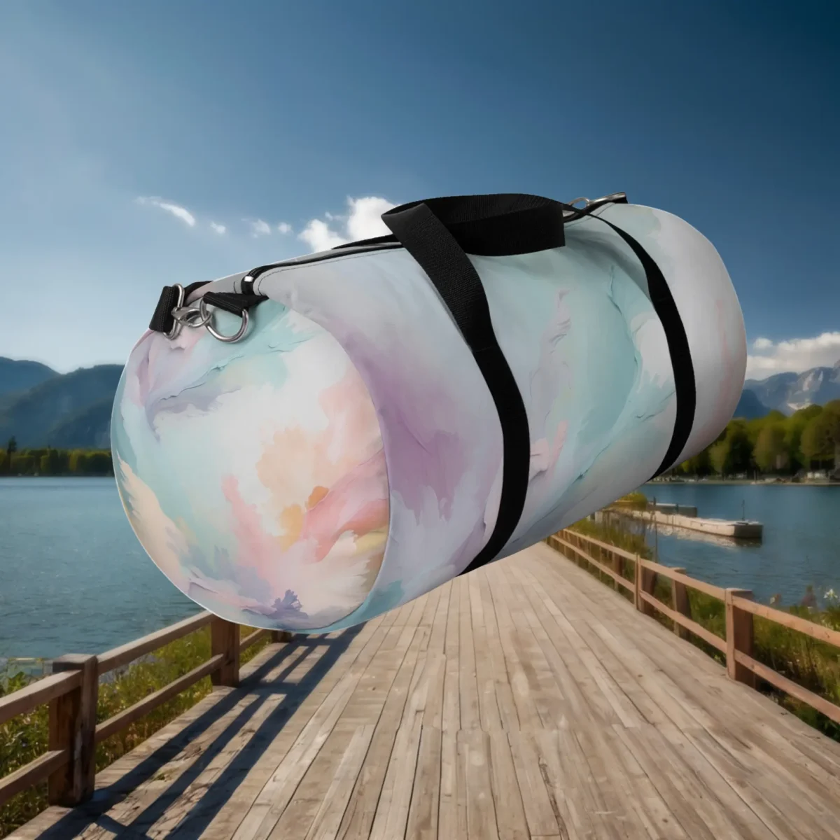 Large duffel bag with pastel watercolor design and black straps shown diagonally on a wooden dock.