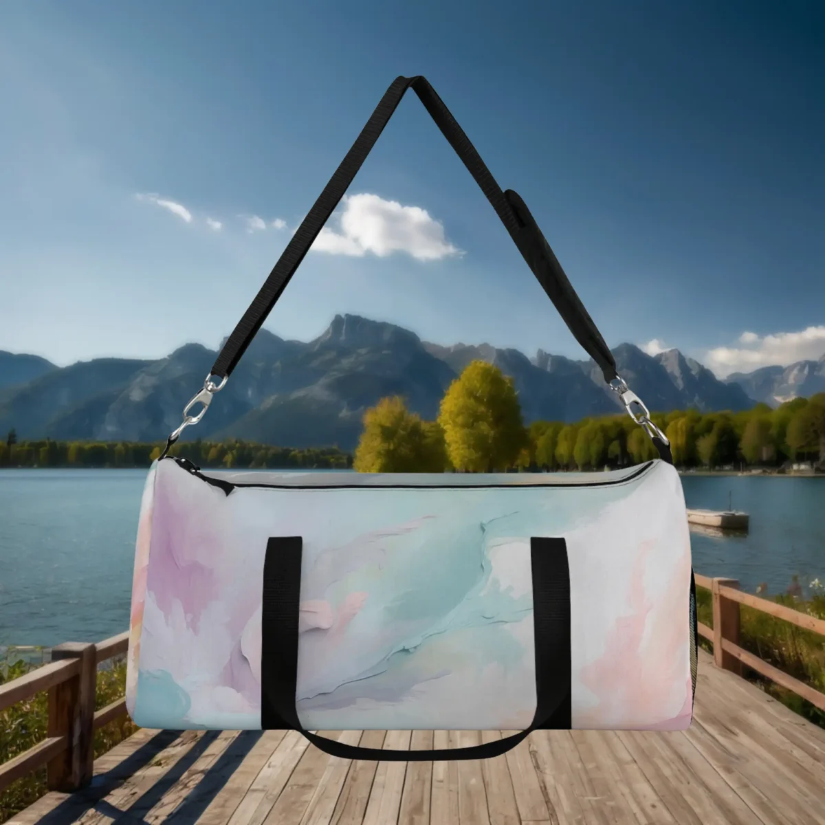 Large pastel watercolor duffel bag with black handles and strap, suspended above a dock by the lake.