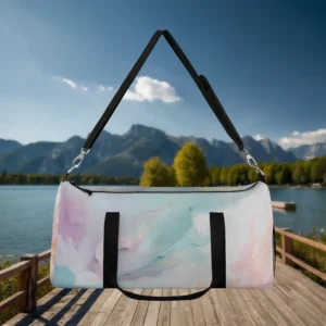 Large pastel watercolor duffel bag with black handles and strap, suspended above a dock by the lake.