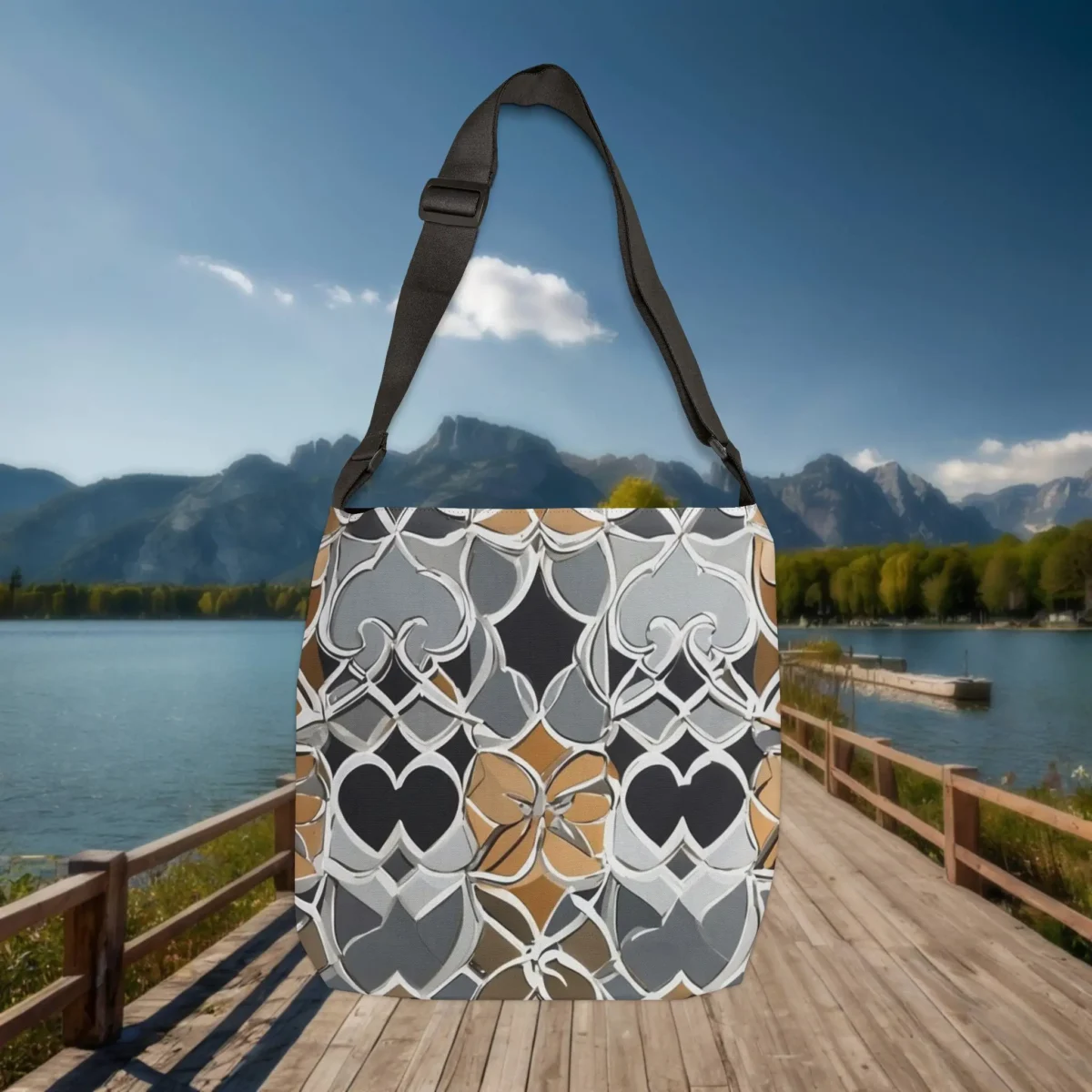 Flat lay of Moroccan pattern tote bag with gray, brown, and black design, placed outdoors with mountain lake background.