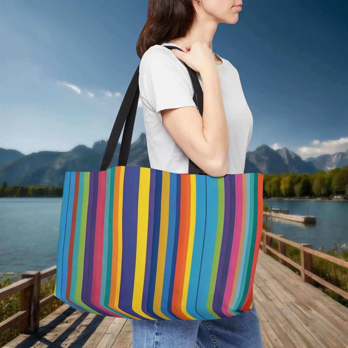 Woman carrying a weekender tote bag with bright vertical multicolor stripes