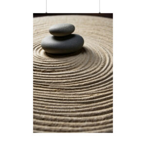 Two smooth black stones stacked on circular raked sand in a zen garden