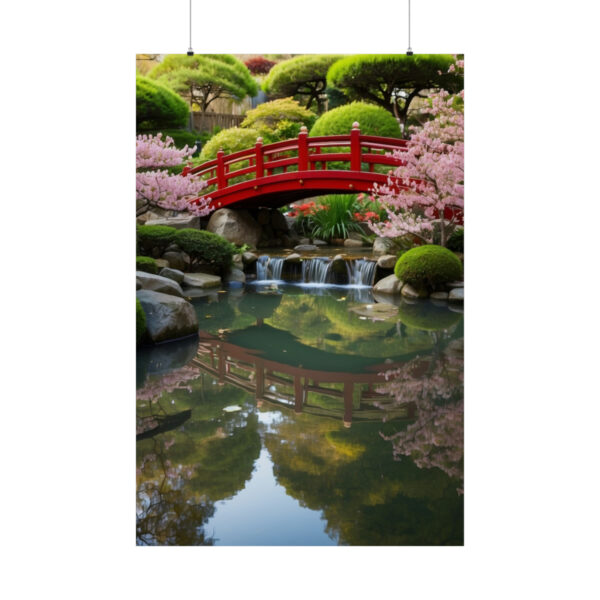 Red bridge over a pond with a small waterfall, surrounded by cherry blossoms and manicured trees