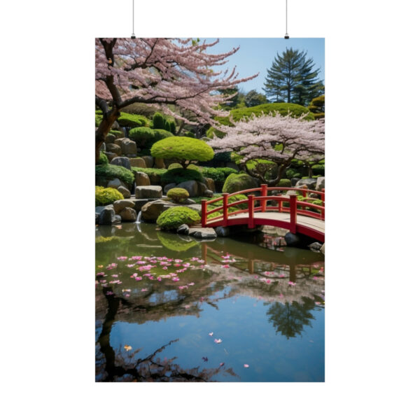 Red bridge over a pond with floating cherry blossom petals and manicured trees