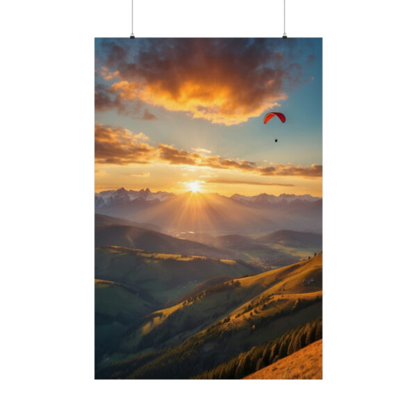 Paraglider flying over sunlit hills and mountains at sunset