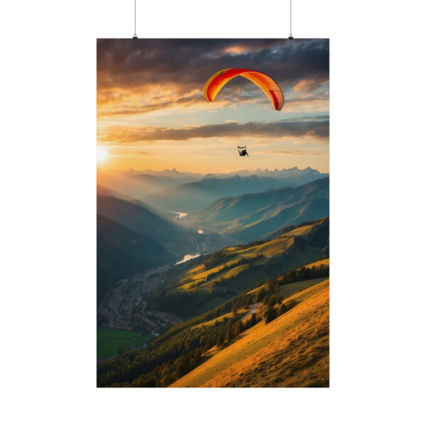 Paraglider soaring over mountains at sunset with valleys and distant peaks