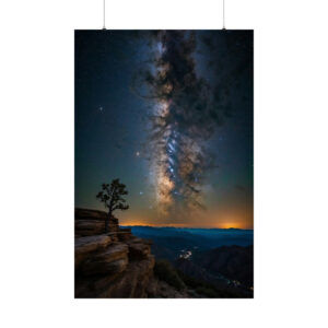 night sky with the Milky Way above a rocky landscape and distant mountains